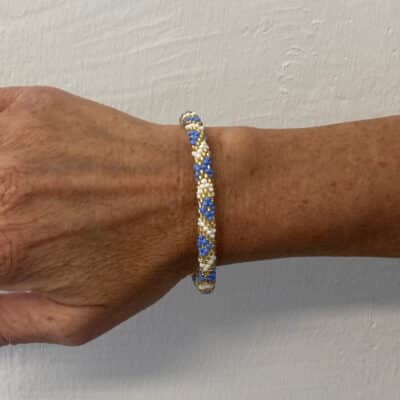 By Stær håndlavet nepal armbånd i hvid, blå og guld. Elegant til alle outfits.